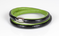 Armbånd i sort lak læder og limegrøn lammeskind. 2 omgange med magnetlås i stål. Tykkelse 7,5 mm.